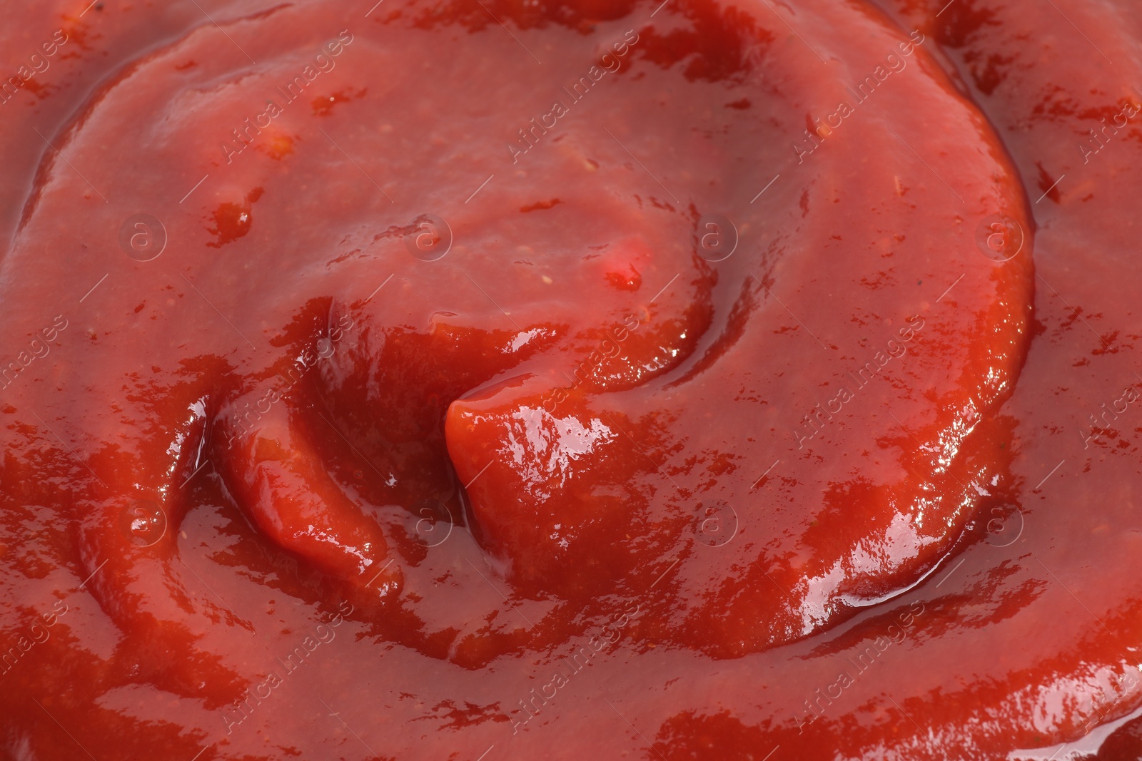 Photo of Tasty ketchup as background, closeup. Tomato sauce