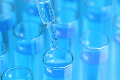 Photo of Dripping reagent into test tube with blue liquid, closeup. Laboratory analysis