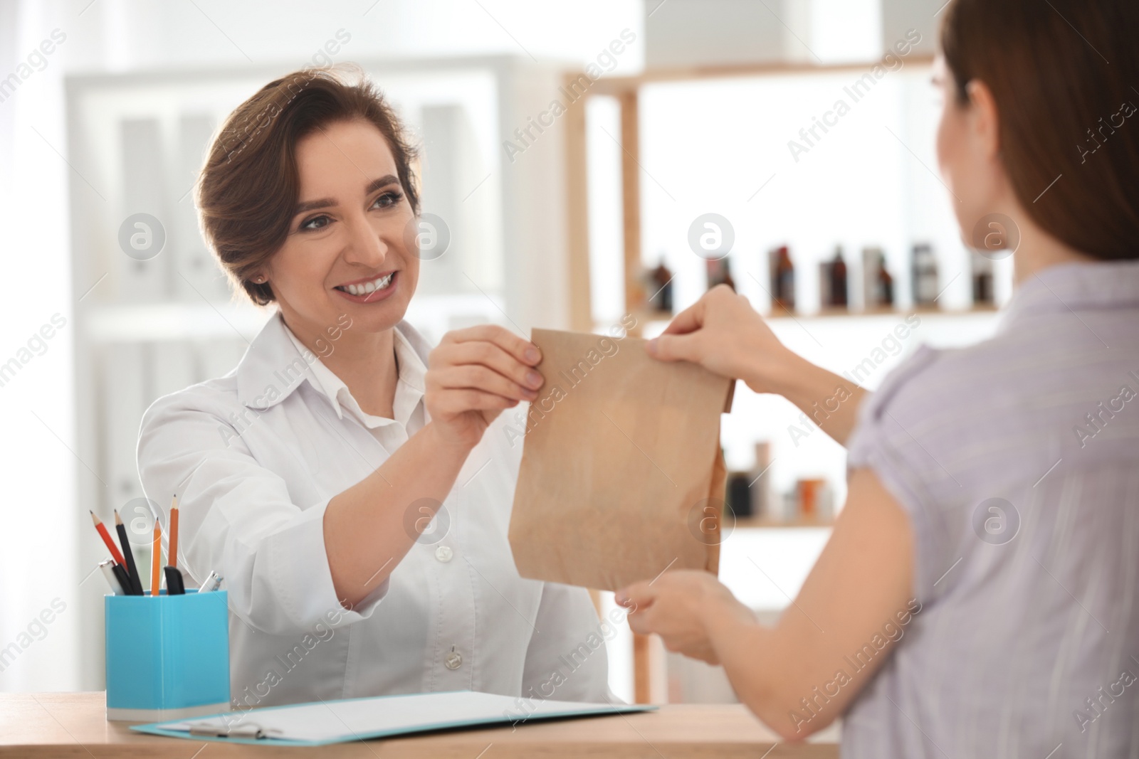 Photo of Pharmacist giving medicine to customer in drugstore