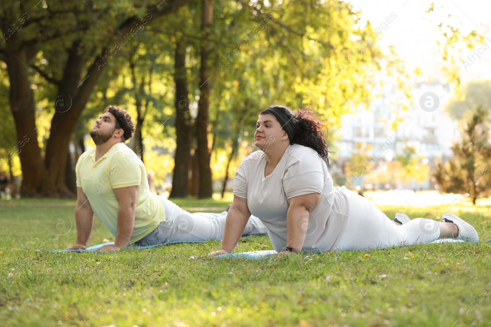 Photo of Overweight couple training together in park on sunny day