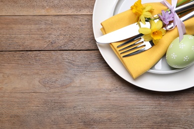 Photo of Festive Easter table setting with egg on wooden background, top view. Space for text