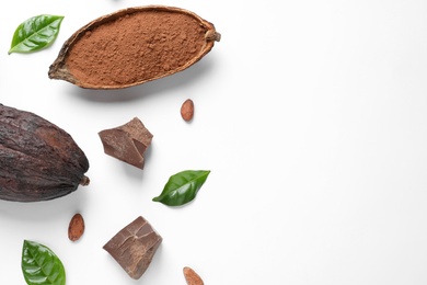 Photo of Cocoa pods with powder, beans and chocolate pieces on white background, top view