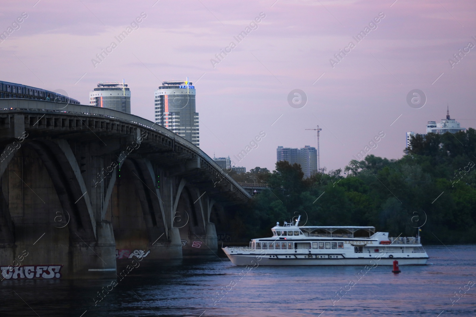 Photo of KYIV, UKRAINE - MAY 23, 2019: Beautiful view of Metro bridge over Dnipro river in evening