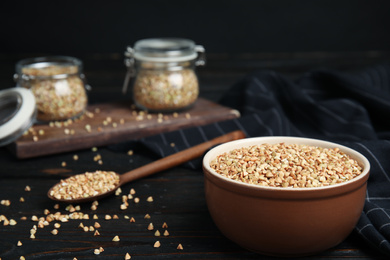 Photo of Organic green buckwheat on black wooden table