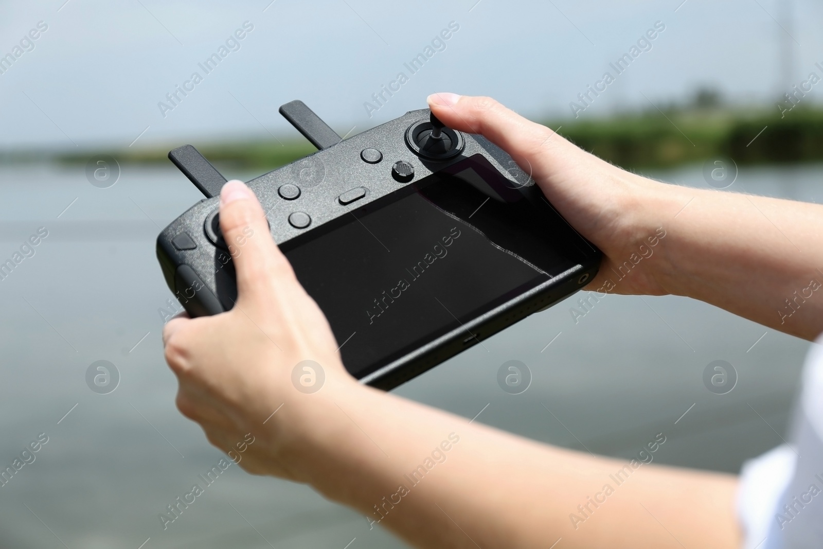 Photo of Woman with modern drone controller outdoors, closeup