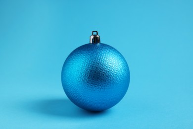 Photo of One Christmas ball on light blue background