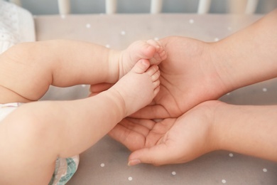 Photo of Mother holding little baby feet in hands