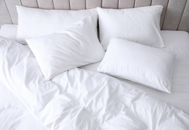 Photo of Comfortable bed with soft white pillows, closeup