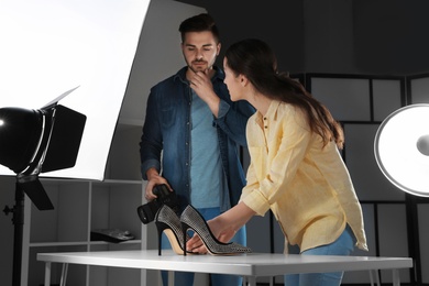 Photo of Professional photographers shooting stylish shoes in studio