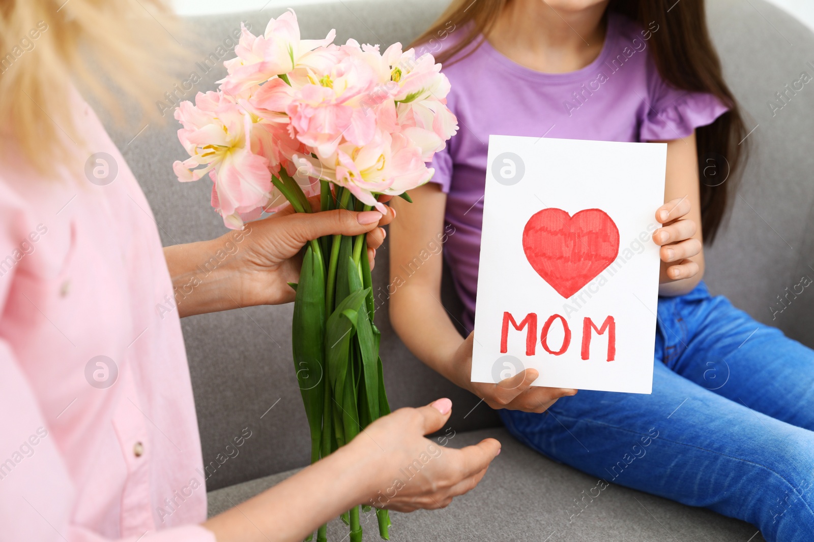 Photo of Little daughter congratulating her mature mom at home, closeup. Happy Mother's Day