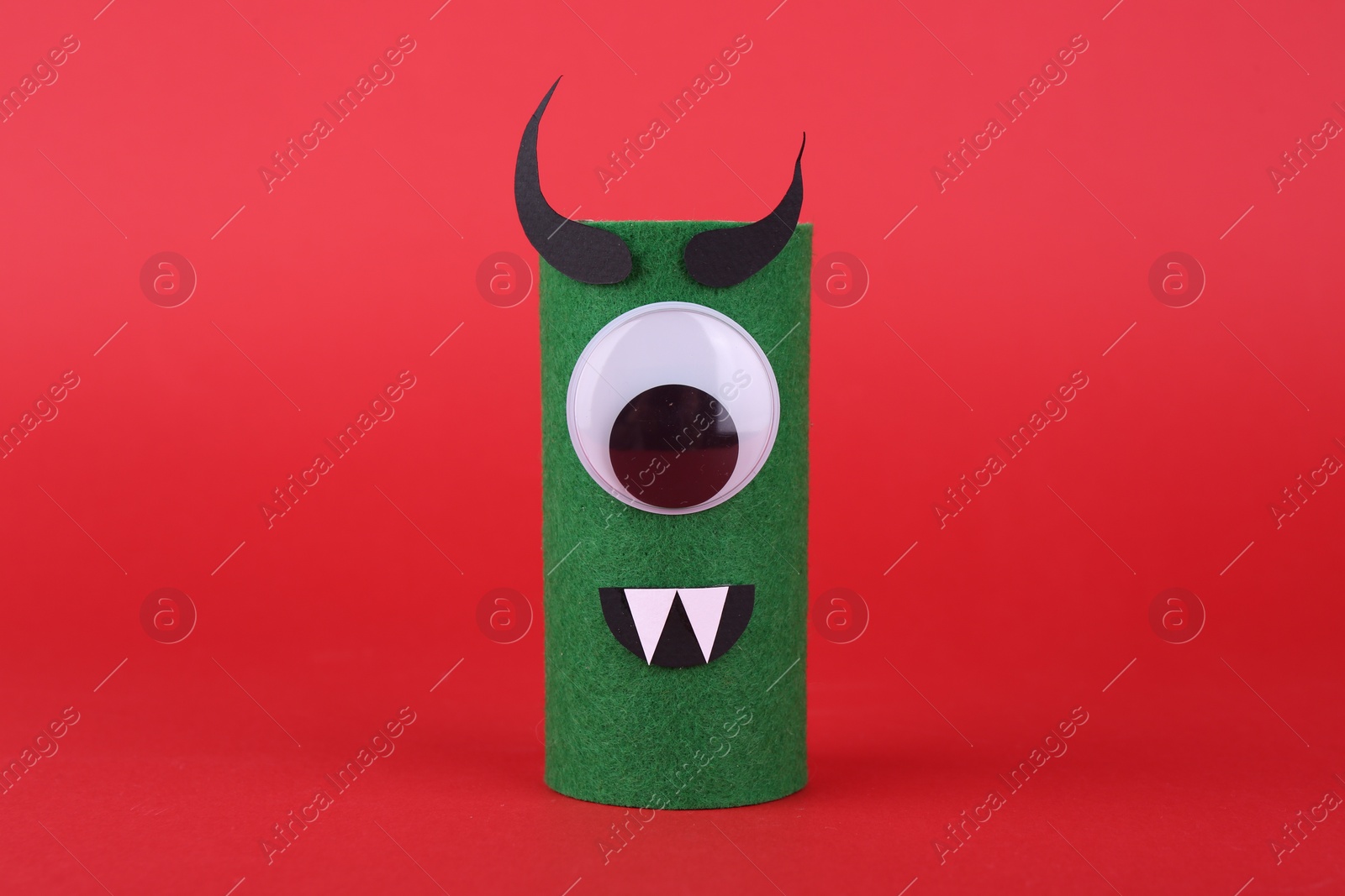 Photo of Spooky monster on red background. Handmade Halloween decoration