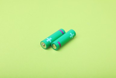 Photo of New AA size batteries on light green background