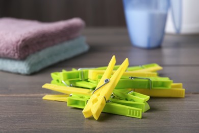 Pile of colorful plastic clothespins on wooden table