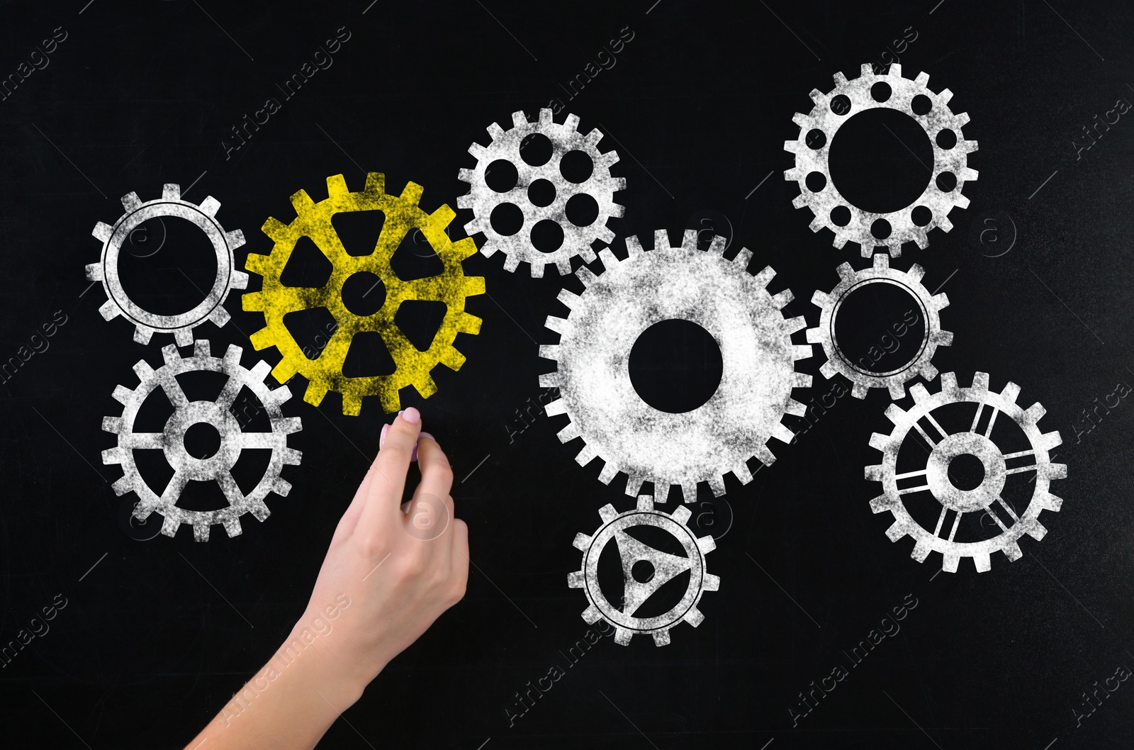 Image of Woman drawing gear mechanism on chalkboard, closeup 