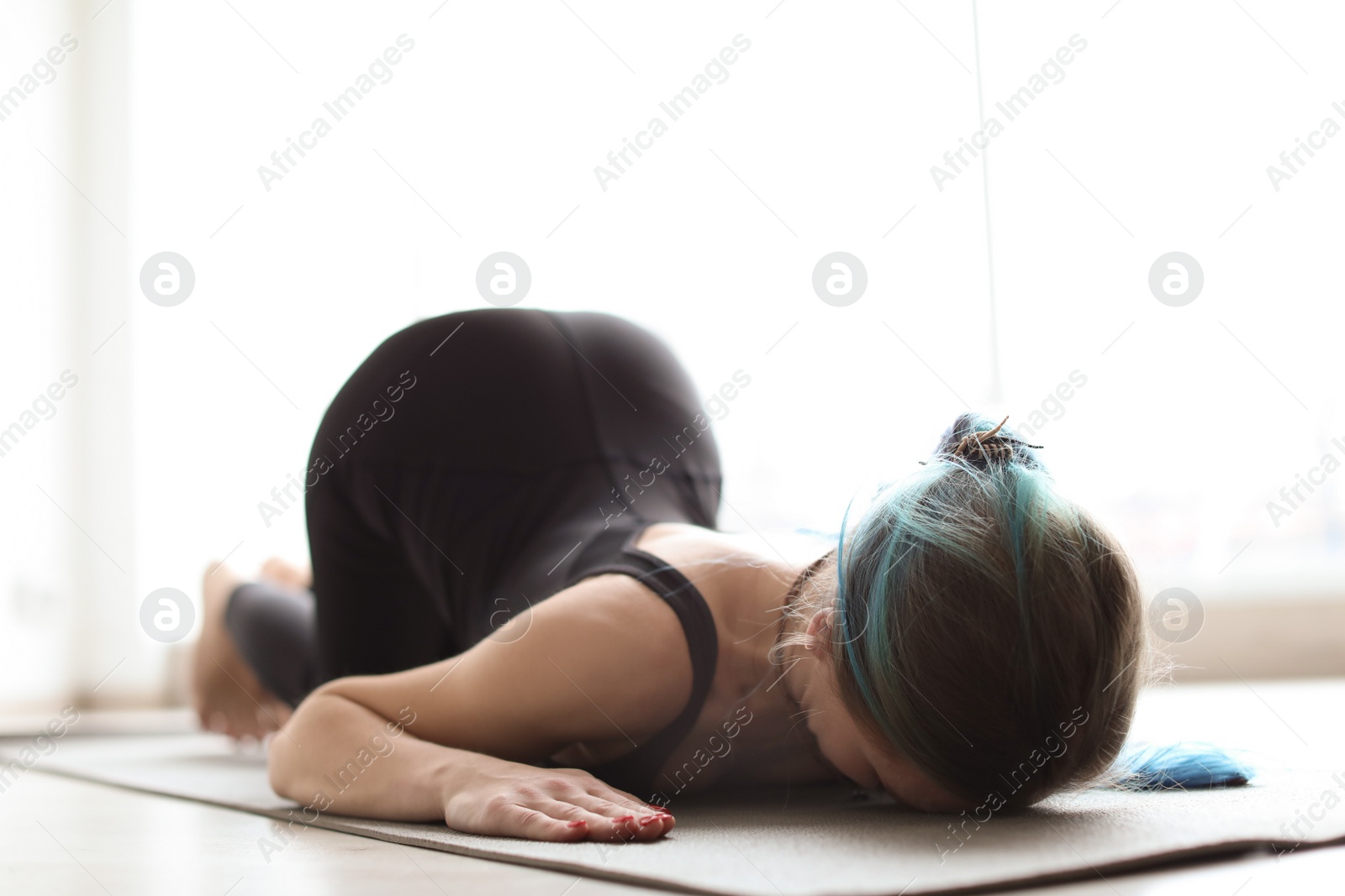 Photo of Young woman practicing yoga indoors