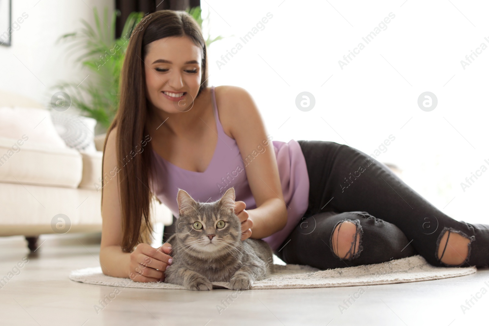 Photo of Young woman with cute cat at home. Pet and owner