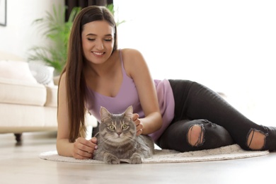 Young woman with cute cat at home. Pet and owner