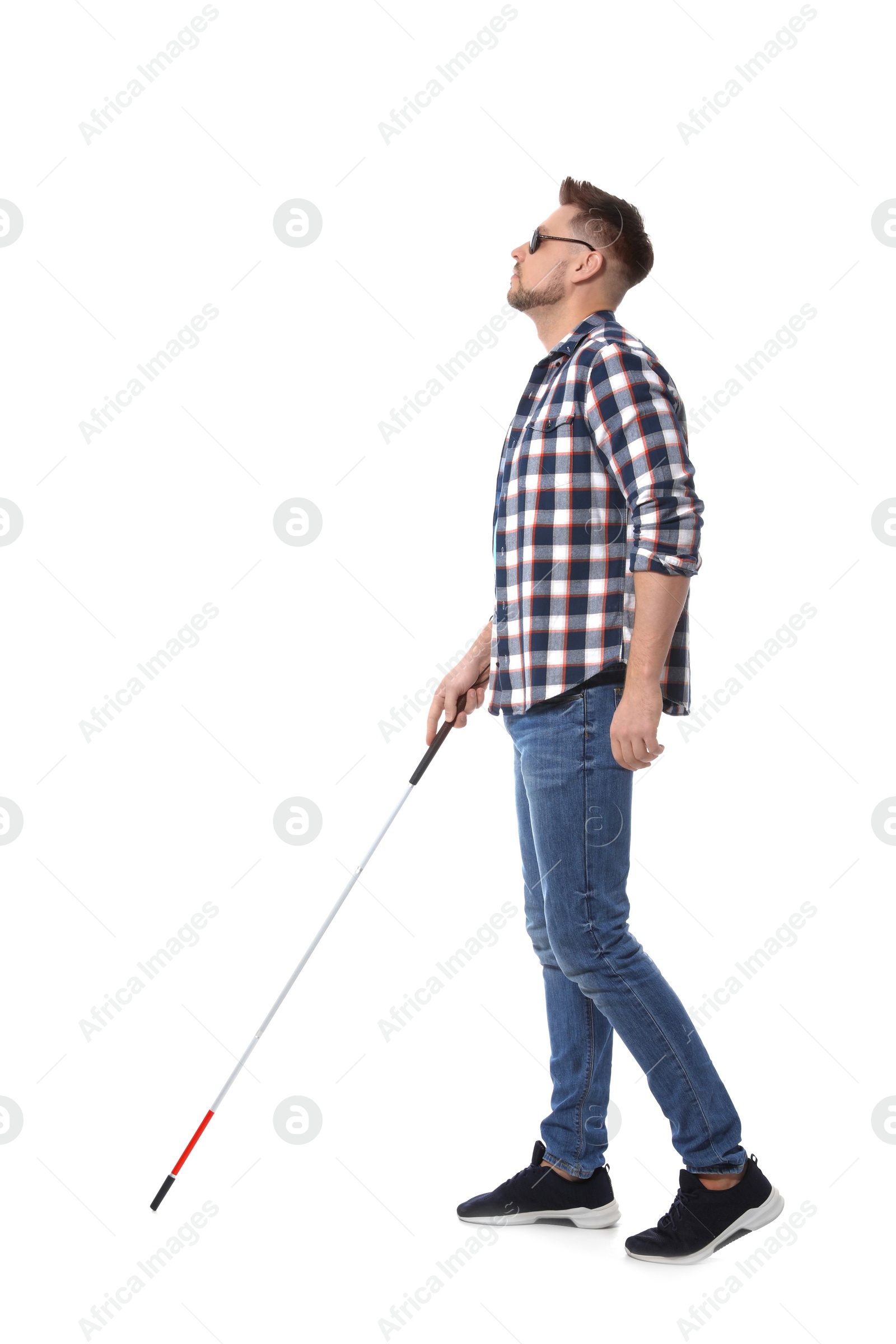 Photo of Blind man in dark glasses with walking cane on white background