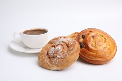 Photo of Delicious rolls with jam, powdered sugar, raisins and cup of coffee isolated on white. Sweet buns