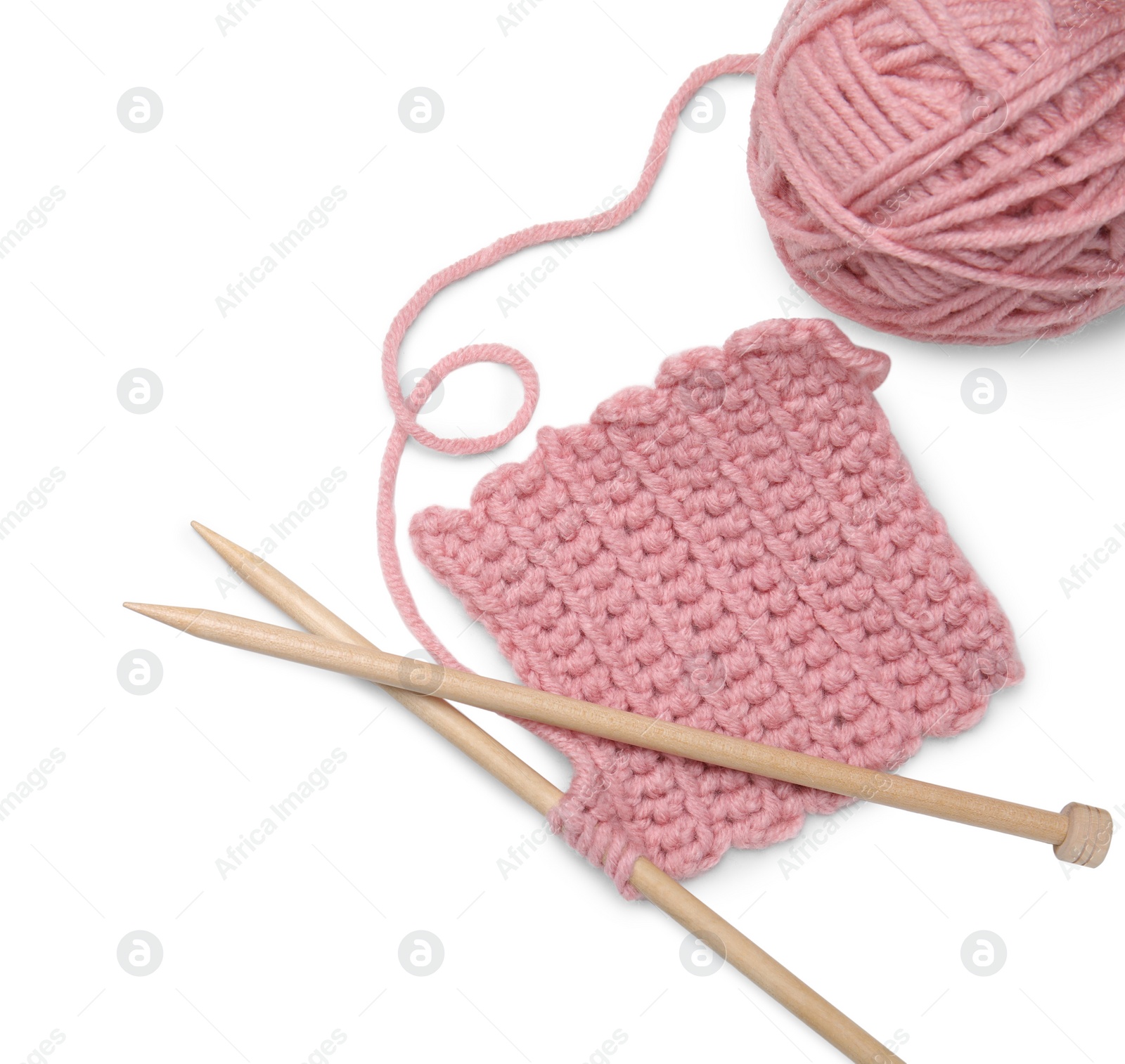 Photo of Soft pink woolen yarn, knitting and wooden needles on white background, top view