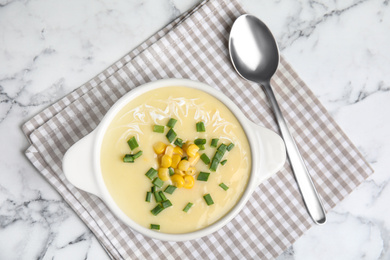 Photo of Delicious corn cream soup served on white marble table, flat lay