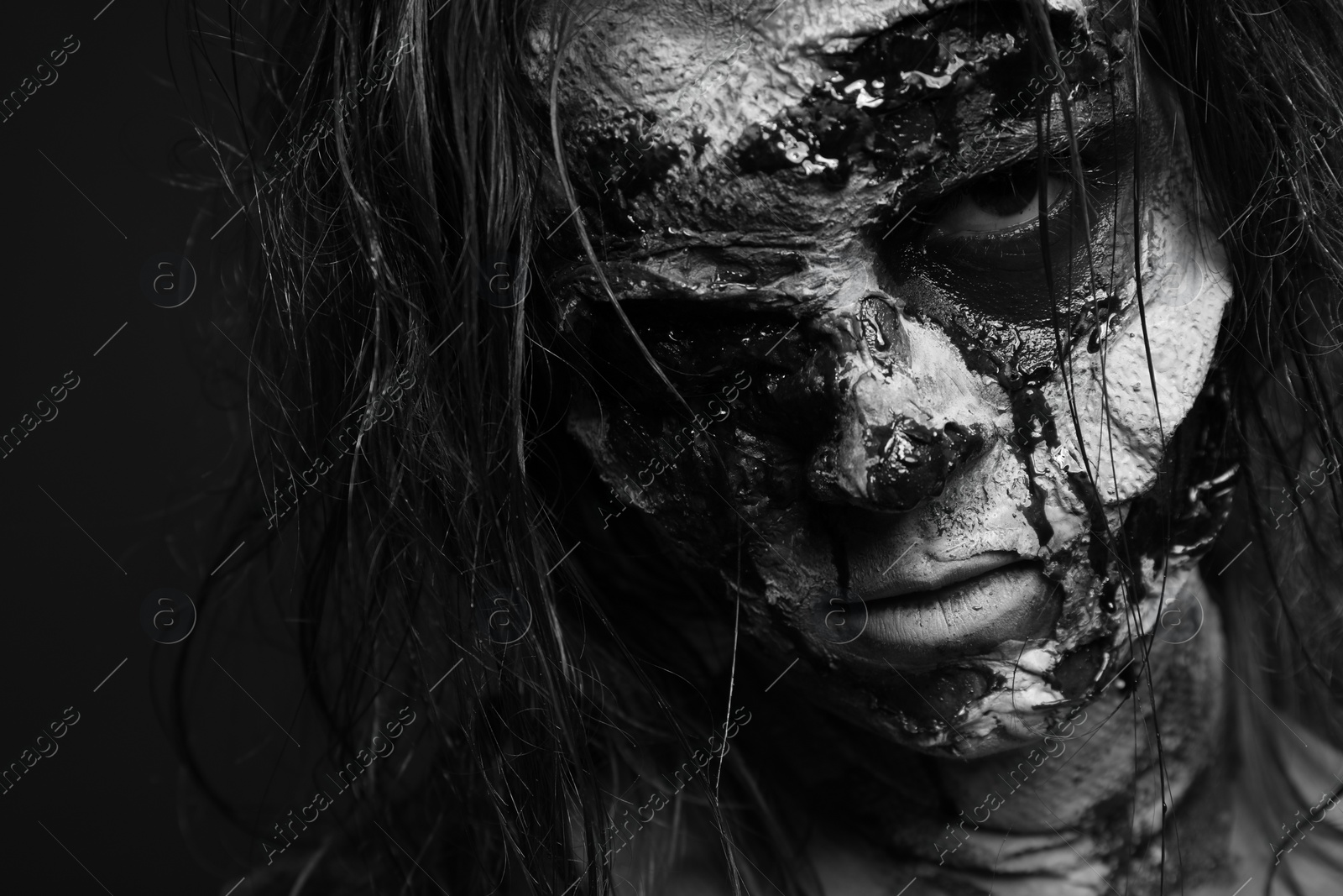 Photo of Scary zombie on dark background, black and white effect. Halloween monster