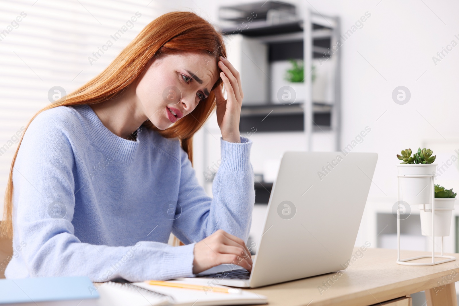 Photo of Woman suffering from headache at workplace in office