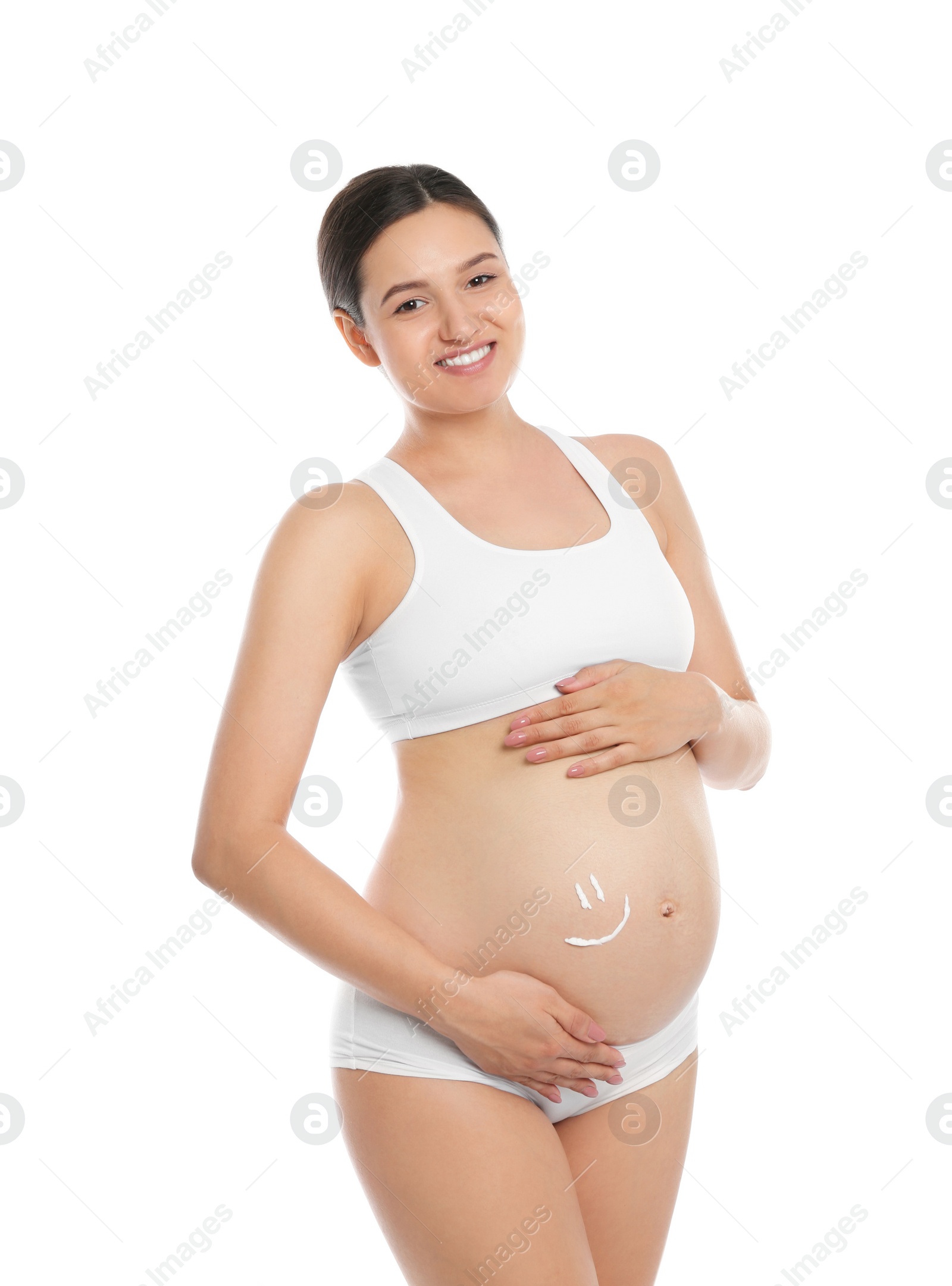 Photo of Pregnant woman with smile painted on her belly against white background. Body cream