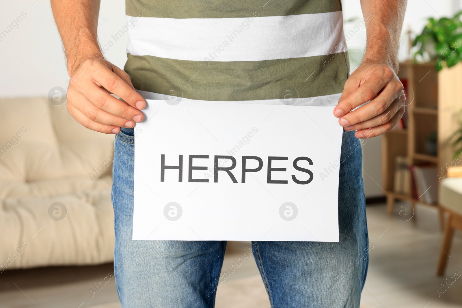 Photo of Man holding paper with word Herpes indoors, closeup