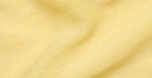 Photo of Texture of bright yellow fabric as background, closeup