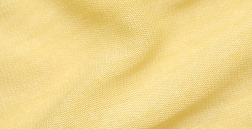 Photo of Texture of bright yellow fabric as background, closeup