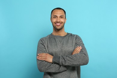 Portrait of handsome young man on light blue background