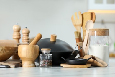 Photo of Set of cooking utensils and products on white table against blurred background