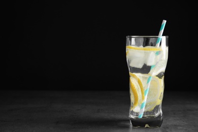 Photo of Soda water with lemon slices and ice cubes on grey table. Space for text