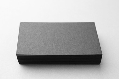 Photo of Blank black business cards on white table, closeup. Mockup for design
