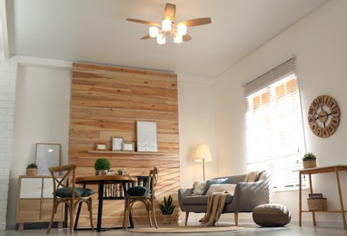 Photo of Stylish living room interior with modern ceiling fan, low angle view