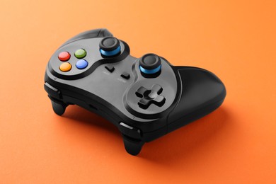 Photo of One wireless game controller on orange background