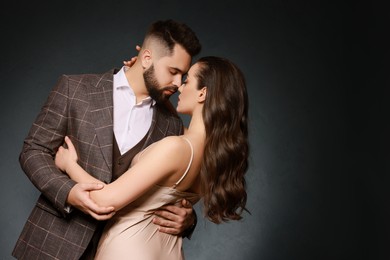 Photo of Handsome bearded man with sexy lady on grey background. Space for text