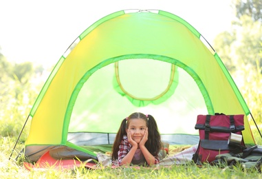 Photo of Little girl resting in tent outdoors. Summer camp