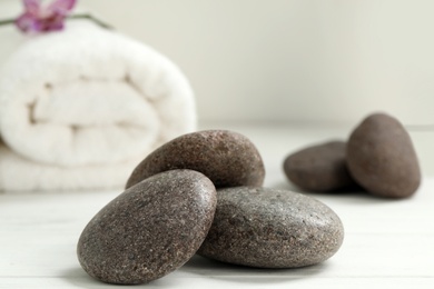 Photo of Pile of spa stones on white wooden table, closeup