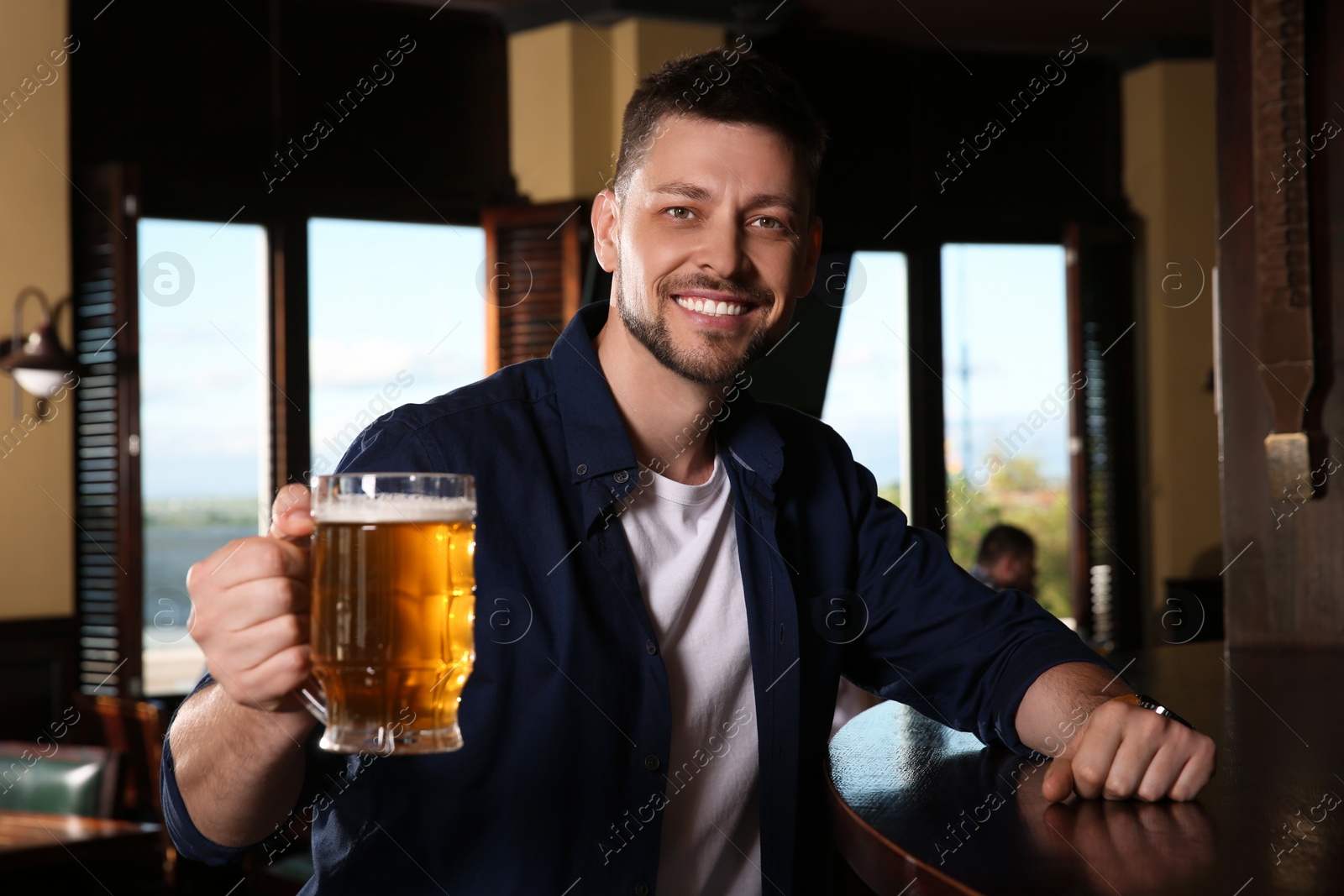 Photo of Man with glass of tasty beer in pub