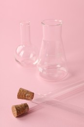 Photo of Flasks and test tubes on pink background. Laboratory glassware