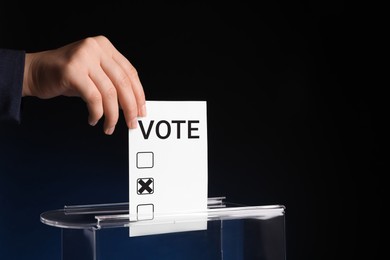 Image of Woman putting paper with word Vote and tick into ballot box on dark blue background