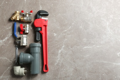 Photo of Flat lay composition with plumber's tools and space for text on grey background