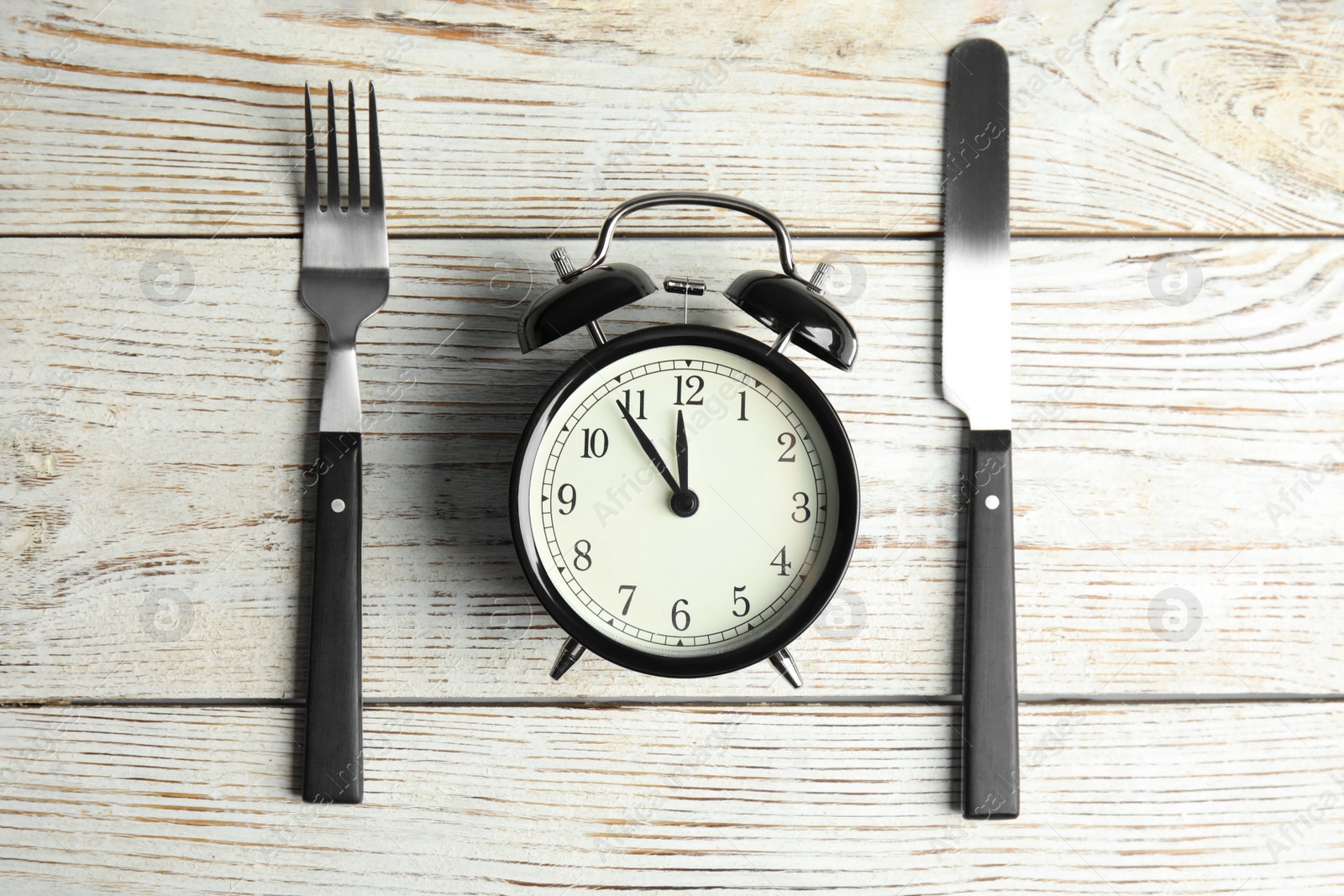 Photo of Alarm clock and cutlery on white wooden table, flat lay. Diet regime