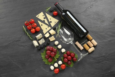 Photo of Tasty red wine and snacks on black table, flat lay