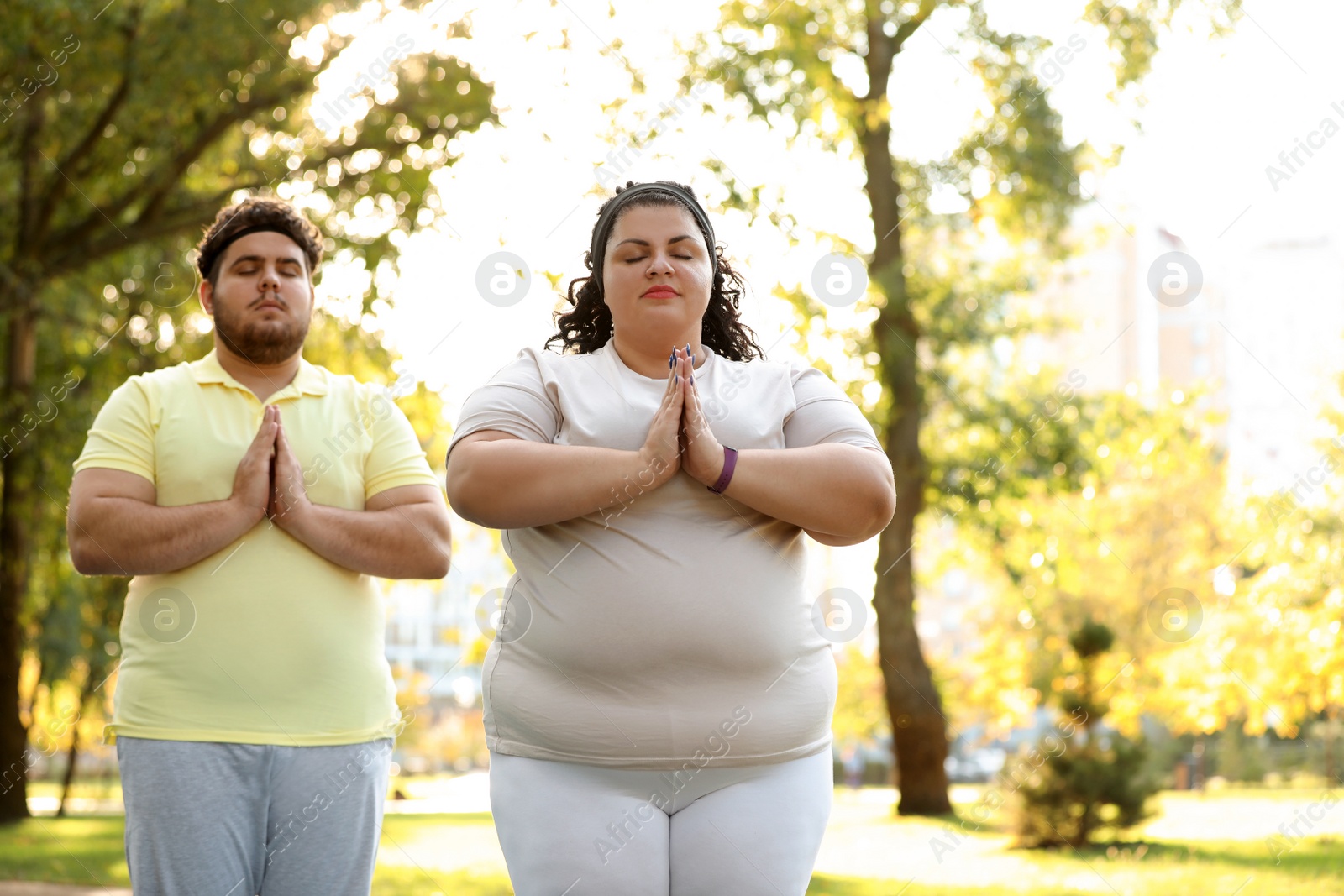 Photo of Overweight couple training together in park on sunny day