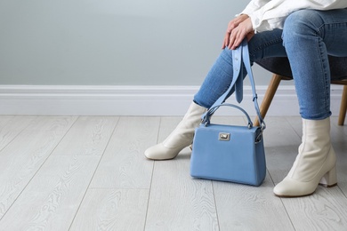 Woman wearing stylish leather shoes with bag indoors, closeup. Space for text