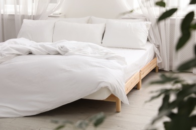 Photo of Comfortable bed with soft pillows in room interior