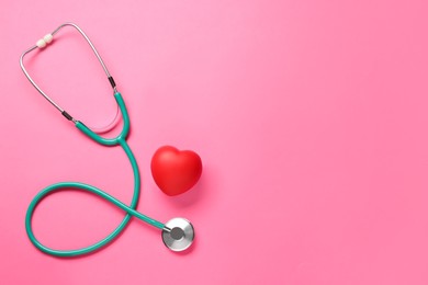 Photo of Stethoscope and red decorative heart on pink background, flat lay with space for text. Cardiology concept